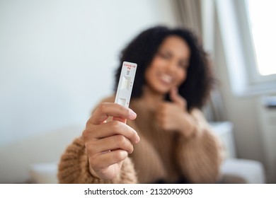 Close-up shot of African-American woman's hand holding a negative test device. Happy young woman showing her negative Coronavirus - Covid-19 rapid test. Focus is on the test.Coronavirus