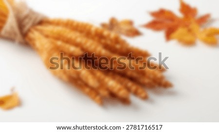 Close-up shot of appetizing breadsticks with fall leaves on a white surface, perfect for food and autumn themes.