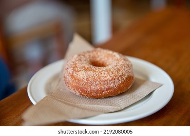 A Closeup Shot Of An Apple Cider Doughnut On A Plate