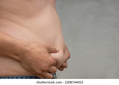 Closeup Shot Of Asian Man Catch Stomach With Jean Trousers And Cement Blur Background, Planning Exercise And Loss Weight For Good Health In The Feature, Healthcare And Gym Concept Copy Space