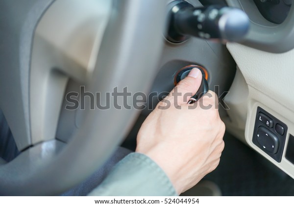 Closeup shot of Asian man hand inserting key in\
igniting car for starting / shutting down car engine, chauffeur car\
driver service background concept\
