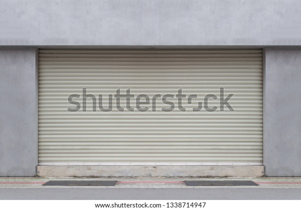A closeup shot of automatic metal roller door\
used in factory, storage, garage, and industrial warehouse. The\
corrugated and foldable metal sheet offer space saving and provide\
urban and rustic feel