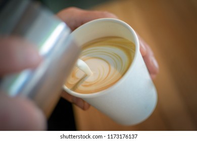 Close-up Shot Of A Barista Preparing A Latte Art In A Paper Cup. Extreme DoF With Natural Daylight. 