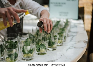 A closeup shot of a barman making lime mojitos on a marble bar stand