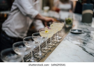 A Closeup Shot Of A Barman Making Margaritas With A Number Of Glasses Set In Line