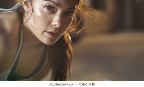 Close-up Shot of a Beautiful Athletic Woman Looks into Camera. She's Tired after Intensive Fitness Exercise.