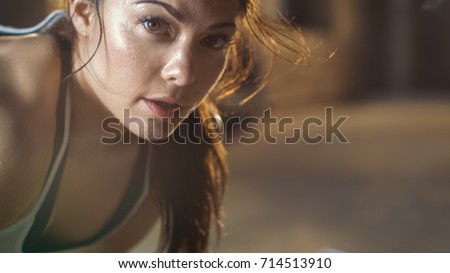 Close-up Shot of a Beautiful Athletic Woman Looks into Camera. She's Tired after Intensive Fitness Exercise.