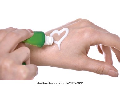 Closeup Shot Of Beautiful Female Hands Holding And Applying Moisturiser. Woman Applying Cream On A White Background