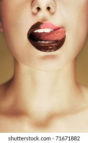 Close-up Shot Of Beautiful Woman Lips With Chocolate, Girl Licking Her Lips. Conceptual Image.