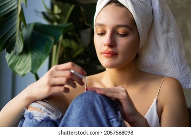 Close-up Shot Of A Beautiful Young Woman Getting Ready For Work. She Is Painting Her Nails While Covering Her Hair With A Towel After Washing.