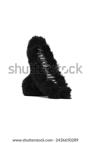 Close-up shot of a black fluffy hair clip. Plush hair claw clip is isolated on a white background. Side view. A fashionable hair accessory with fur.