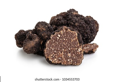 Closeup shot of black truffles and oak leaves isolated on white background.