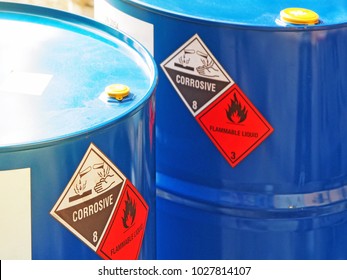 The Close-up Shot Of Blue Color Hazardous Dangerous Chemical Barrels ,have Warning Labels Of Corrosive & Flammable Liquid In Daylight On Daytime.