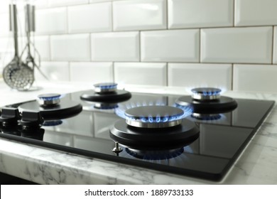 Closeup shot of blue fire from domestic kitchen stove top. Gas cooker with burning flames of propane gas. Industrial resources and economy concept. - Shutterstock ID 1889733133