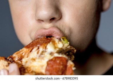 Close-up Shot Of Boy, Biting Pizza.