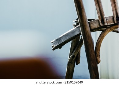 A closeup shot of a broken wooden chair on blurred background