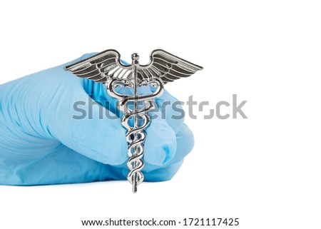 Close-up shot of a Caduceus symbol in a female hand wearing a blue nitrile glove isolated on white.