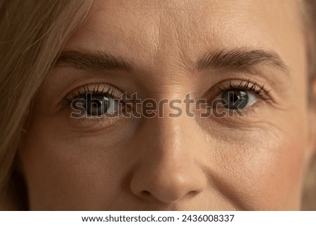 A close-up shot captures the contemplative expression of a mature woman. Her gaze is fixed off-camera, suggesting deep thought or reflection. The subtleties of her facial features, such as the fine