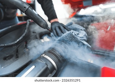 Closeup shot of car detailing process. Car washing cleaning engine. Cleaning car using steam. Steam engine washing. . High quality photo - Powered by Shutterstock