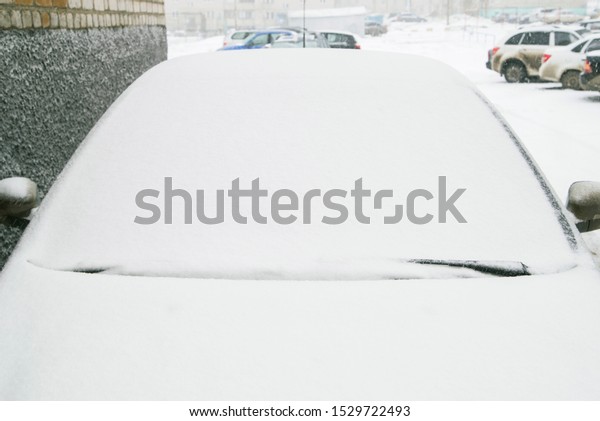 Close-up shot of a\
car\'s windscreen wiper covered in snow. snow on the car window.\
Snow-covered car\
windshield