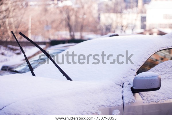 Close-up\
shot of a car\'s windscreen wiper covered in\
snow