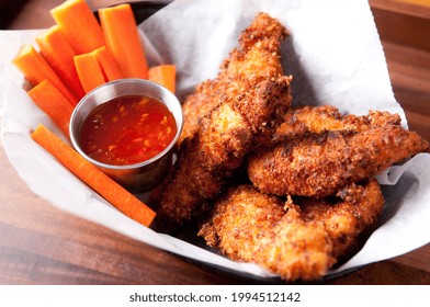 A Closeup Shot Of Chicken Tenders Or Strips With A Spicy Chili Sauce And Vegetable Sticks