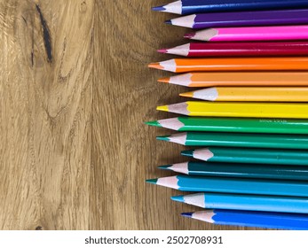 A close-up shot of colorful pencils on a wooden desk, perfect for art, creativity, and educational projects. - Powered by Shutterstock