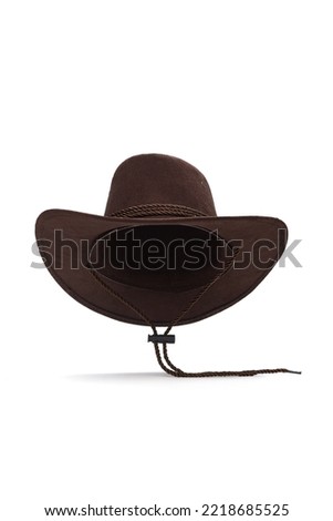 Close-up shot of a dark brown wide-brimmed cowboy hat with a chin strap. The men's cowboy hat is isolated on a white background. Front view.