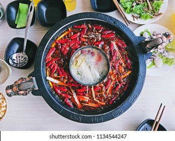 Closeup Shot Of The Delicious Chinese Food, Super Hot And Spicy Sichuan Hotpot Showing Chillis, Sichuan Pepper Seeds And Other Chinese Herbs In The Oil Soup.