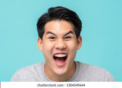 Closeup Shot Of Delighted Excited Asian Man Face Isolated On Light Blue Background