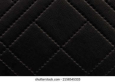 A Close-up Shot Of A Detail Of A Black Quilted Leather Clutch Bag