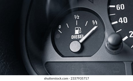 Close-up shot of a diesel fuel gauge in a car. The meter pointer showing that the tank is completely full. Glare of light present on the gauge glass cover. Copy space