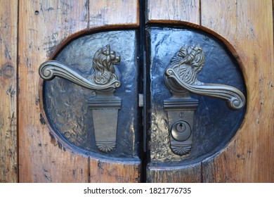 Nahaufnahme von Türgriffen mit Löwenschnitten an einer Holztür