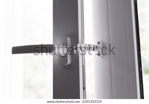 Close-up shot of a double-glazed plastic door\
frame, one-way balcony window handle,PVC window latch fixes the\
sash.House door and window repair\
concept.