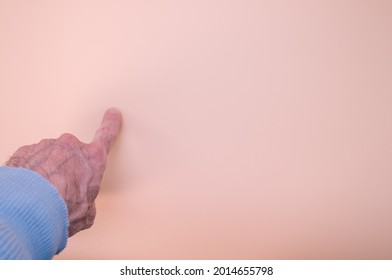 A Closeup Shot Of An Elderly Hand Pointing On A Soft Cream Background