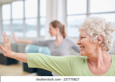 Close-up Shot Of Elderly Woman Doing Stretching Workout At Yoga Class. Women Practicing Yoga At Health Club.