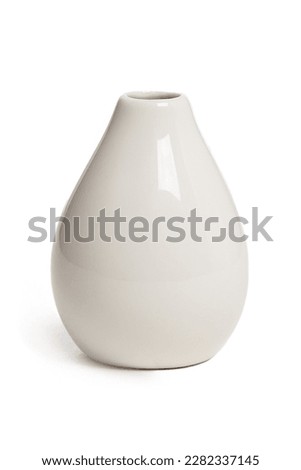 Close-up shot of an empty small ceramic vase covered with glaze. A white glossy vase with a narrow neck is isolated on a white background. Home decor element. Front view.