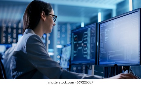 Close-up Shot of Female IT Engineer Working in Monitoring Room. She Works with Multiple Displays. - Powered by Shutterstock