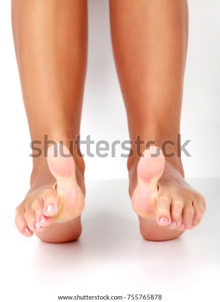 Closeup shot of\
female feet with big toes\
up.