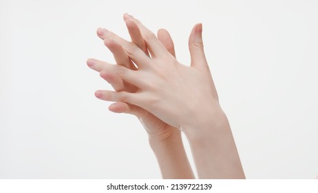 Close-up shot of female hands interlocked fingers on white background | Moisturizing hand care concept
