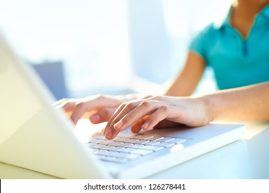 Close-up shot of a female learner typing on the laptop keyboard - Powered by Shutterstock