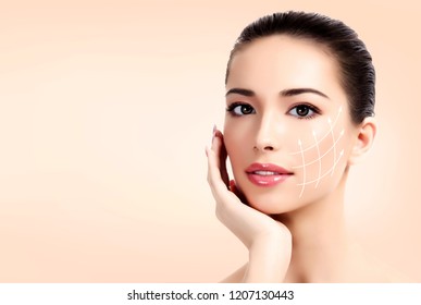 Closeup shot of female pretty face with white arrows on skin for cosmetic medical procedures, pastel background. Skin care concept