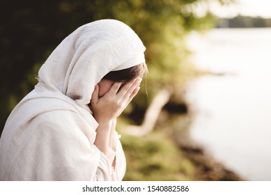 A closeup shot of a female wearing biblical robe crying  - concept confessing sins