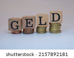 A closeup shot of four group of coins with four cubes on them has letters GELD on isolated background