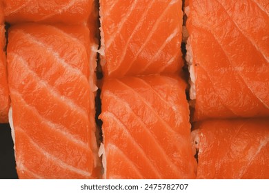 A close-up shot of freshly prepared salmon sushi rolls, showcasing the vibrant orange color of the fish and the delicate texture of the rice. - Powered by Shutterstock