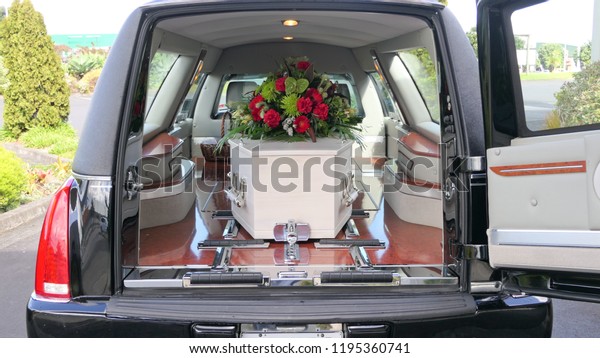 closeup shot of a funeral casket in a hearse\
or chapel or burial at\
cemetery\
