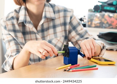 Close-up shot of a girl sharpening pencils using a special creative sharpener	 - Powered by Shutterstock