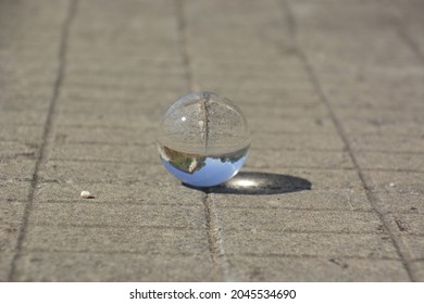 Close-up Shot Of A Glass Sphere That Reflects The Whole Environment That Surrounds It By Turning It Upside Down