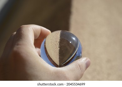 Close-up Shot Of A Glass Sphere That Reflects The Whole Environment That Surrounds It By Turning It Upside Down