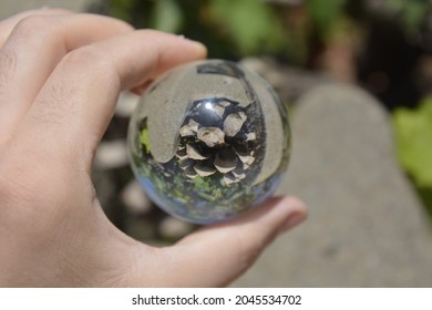 Close-up Shot Of A Glass Sphere That Reflects The Whole Environment That Surrounds It By Turning It Upside Down